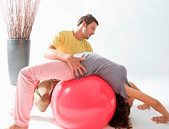A chiropractor using a training ball